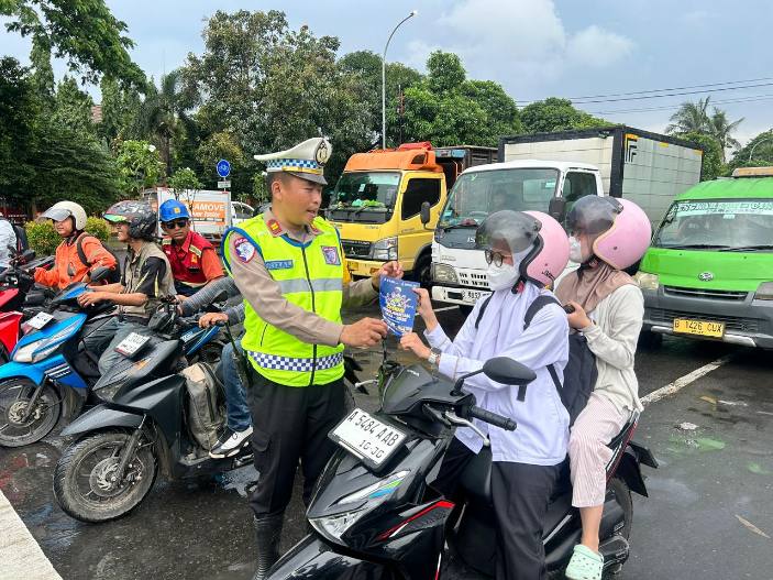 Foto: Kanit Turjawali Polres Metro Tangerang Kota, IPTU Rizal Saat Bagikan Flayer Kepada Pengguna Jalan Edukasi Keselamatan Berkendara. 