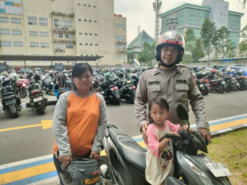 Foto: Anggota SPKT Polres Metro Tangerang Kota, Bripka Agus Yudi Sektio, Saat Mempertemukan Bocah Tersesat Kepada Orang Tuanya. 