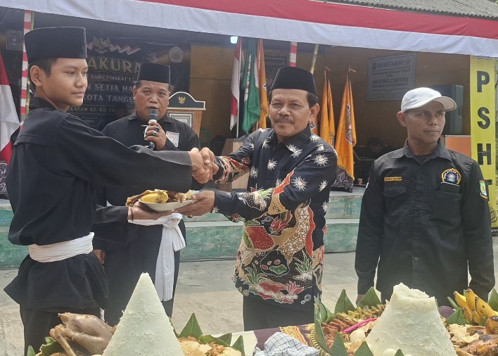 Foto: Ketua Cabang PSHT Kota Tangerang, Kang Mas Sarju Saputro Saat Melakukan Potong Tumpeng Saat Menghadiri Acara Tasyakuran Warga Baru Tingkat 1 Angkatan Ke-VII Tahun 2026.
